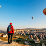 **Cappadocia Landscape:** "A fully clothed traveler in modest hiking attire stands on a hill overlooking the surreal landscape of Cappadocia, Turkey. Hot air balloons dot the early morning sky. Fairy chimneys and rock formations fill the scene. Perfect anatomy, correct proportions, natural pose, safe for work, appropriate content, family-friendly, professional photography, high quality."